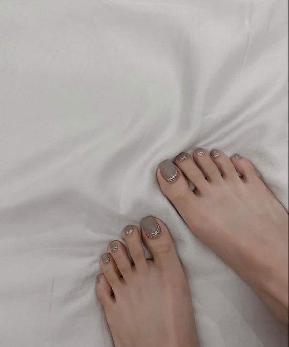 Móng chân của người trung niên sơn màu nude tinh tế, sáng sủa